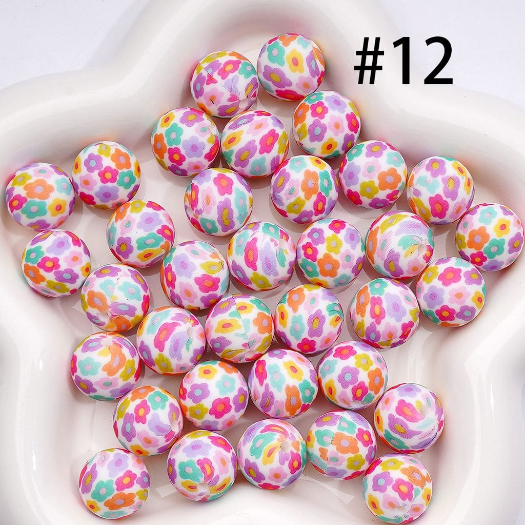 Colorful floral-patterned beads on a white plate with the number 12.

