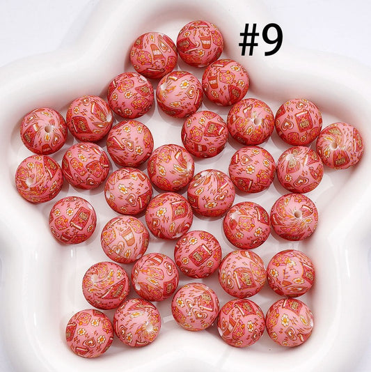 Pink beads with decorative patterns on a white surface

