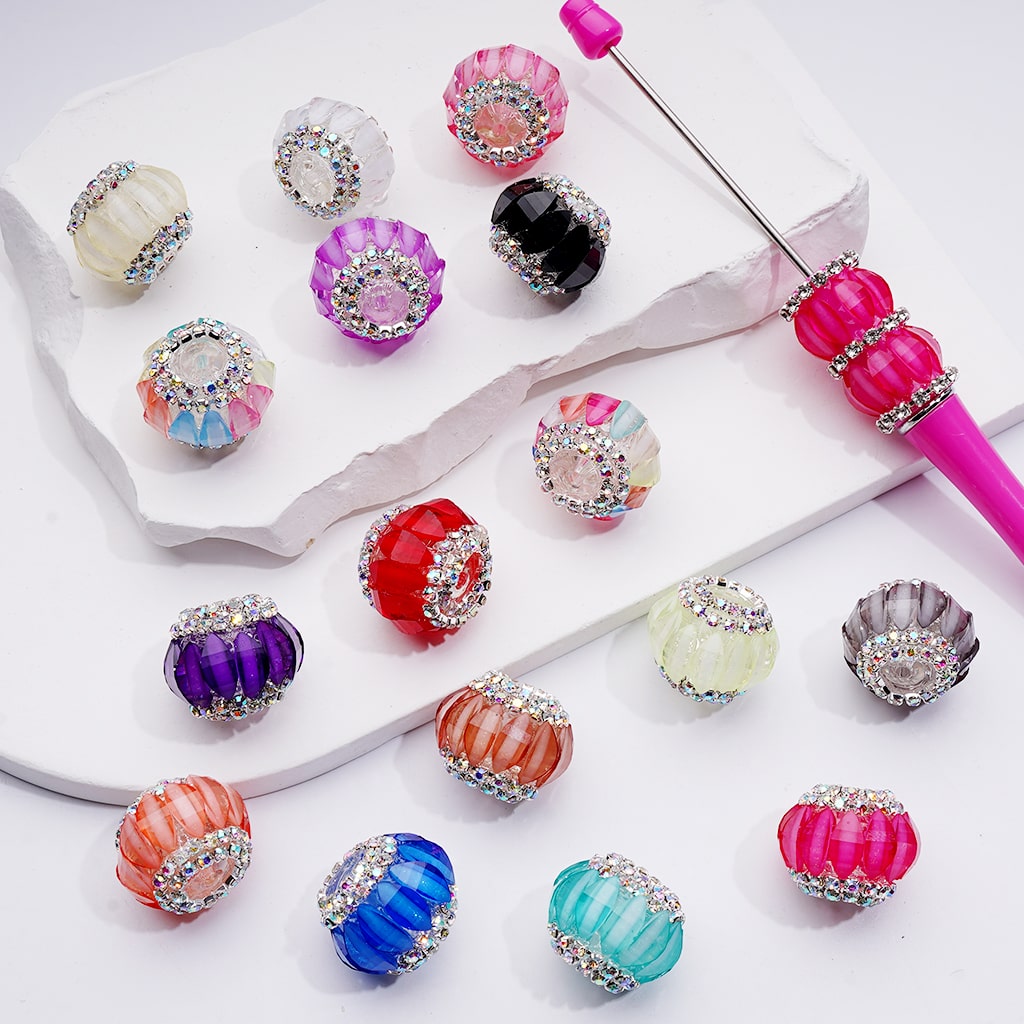 Colorful beaded earrings with a pink tool on a white background

