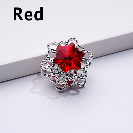 Silver brooch with a red gemstone on a white background

