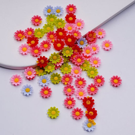 A collection of colorful mini daisy-shaped beads in various colors scattered on a surface.

