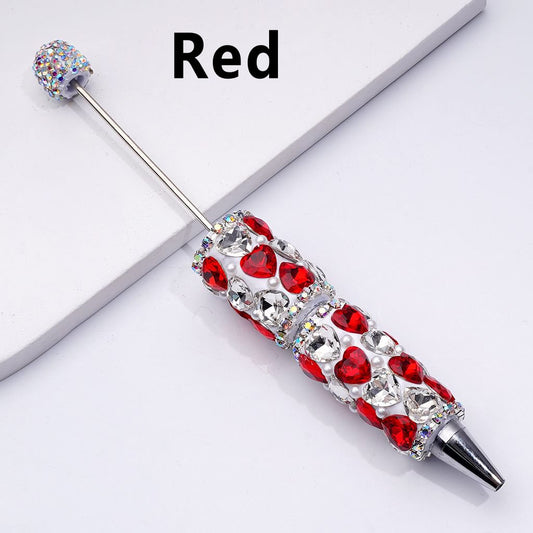 Decorative pen with red and clear gemstones on a white background

