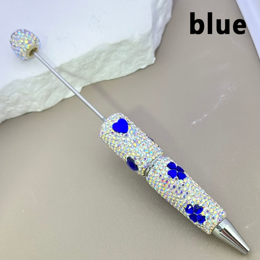 Decorative pen with blue gemstones on a white background
