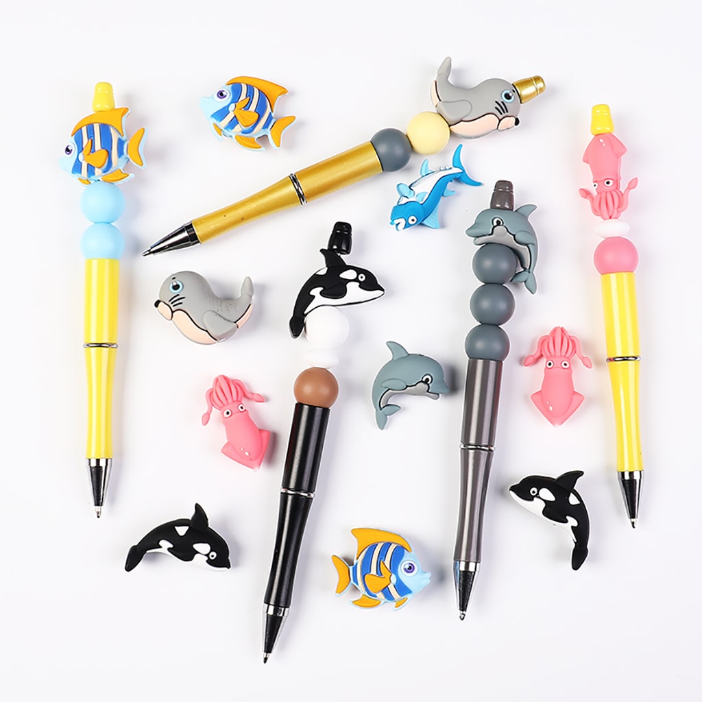 Set of pens with animal-shaped clips on a white background