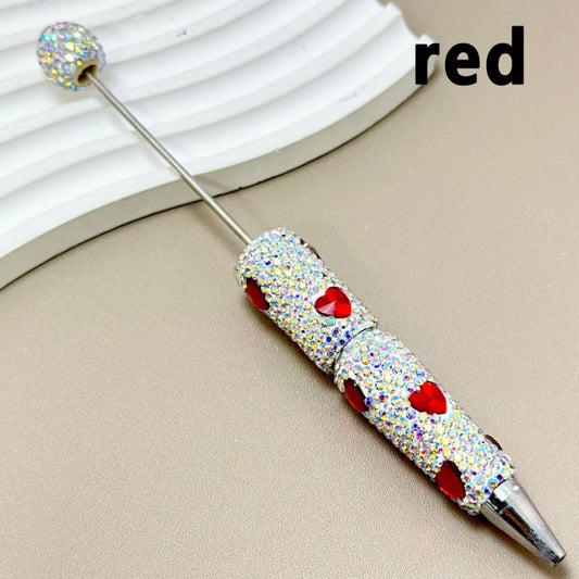 A collection of pens covered in multicolored rhinestones, laid out on a white surface.

