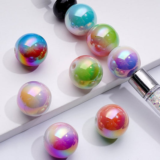 A collection of round acrylic beads in various colors with a metallic sheen, displayed on a white surface.

