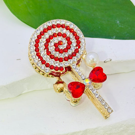 A collection of rose gold alloy lollipop-shaped brooches, each adorned with colorful shiny rhinestones, heart-shaped diamonds, white pearls, and clay beads.

