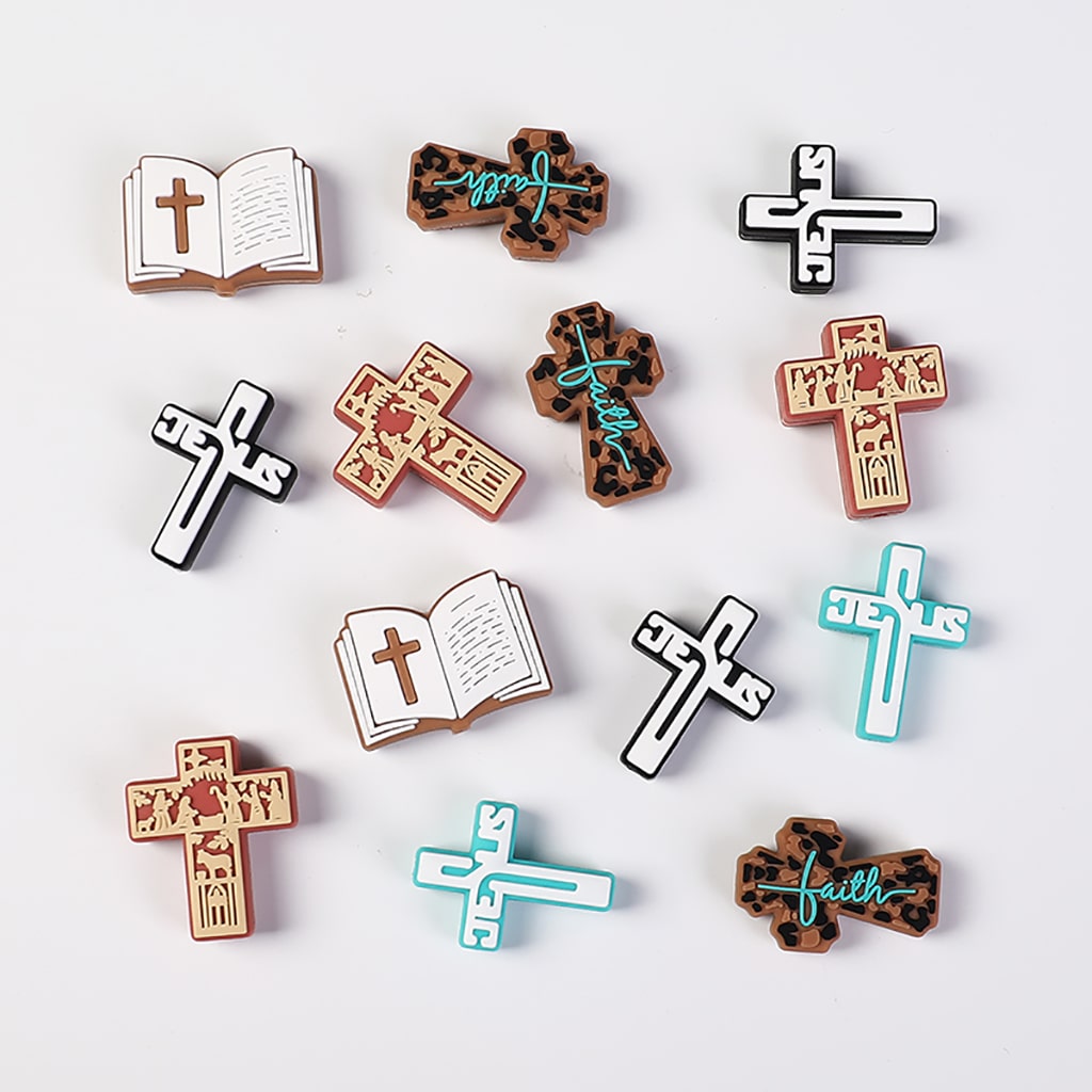 Collection of various cross-shaped pins with different designs on a white background