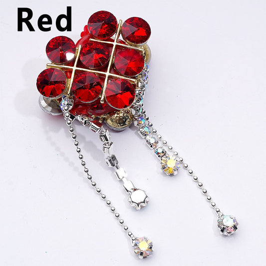 Decorative brooch with red gemstones and silver chain on a white background

