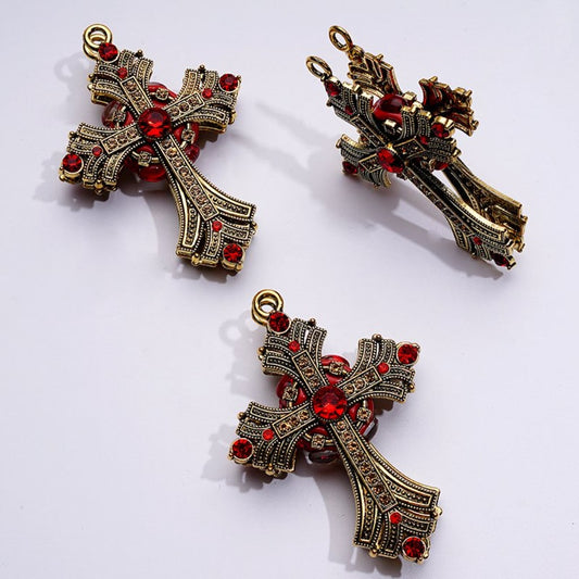 A collection of dark gold alloy crosses with sparkling rhinestones and small ring embellishments in various colors.

