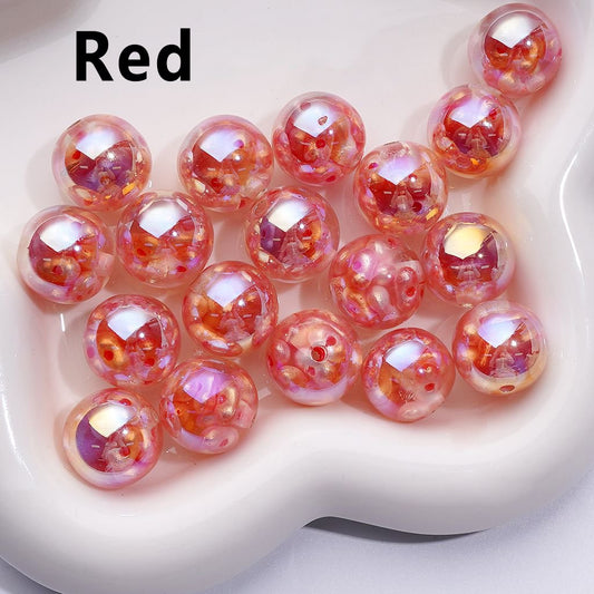 A collection of multicolored glossy resin beads with a reflective surface, displayed on a white surface.


