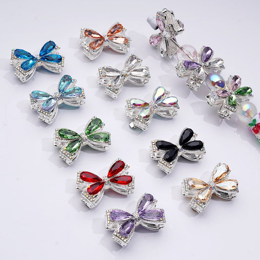 Colorful bow-shaped jewelry pins on a white background

