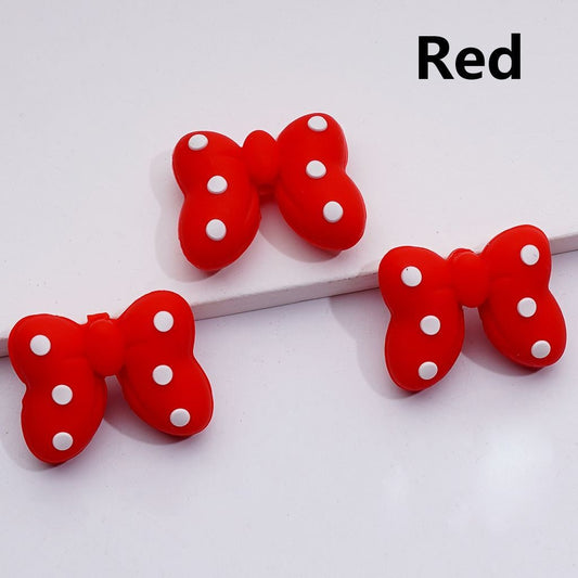 Red bow-shaped objects with white polka dots on a white background

