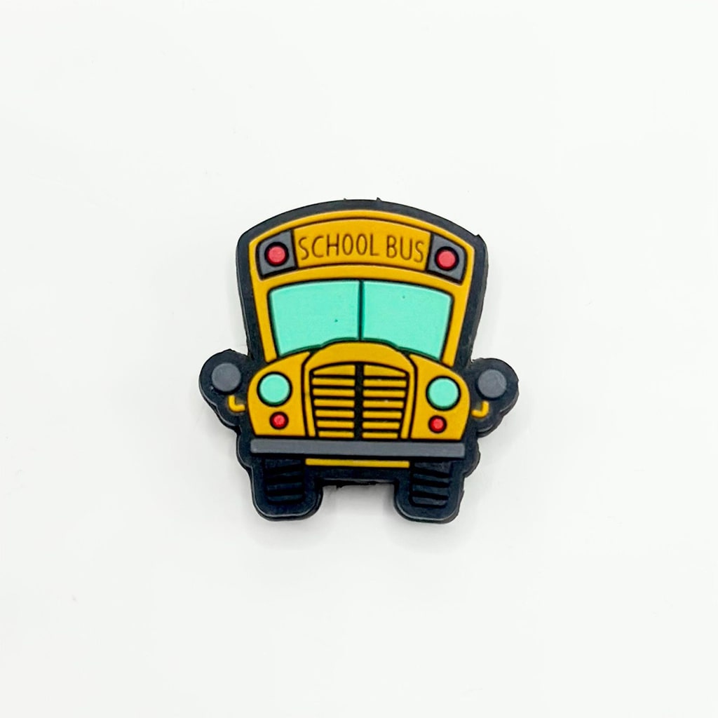 A silicone bead in the shape of a yellow school bus with black wheels and trim, and a blue sky background.

