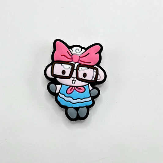 A silicone bead featuring a cartoon illustration of a lamb wearing glasses and a pink bow.

