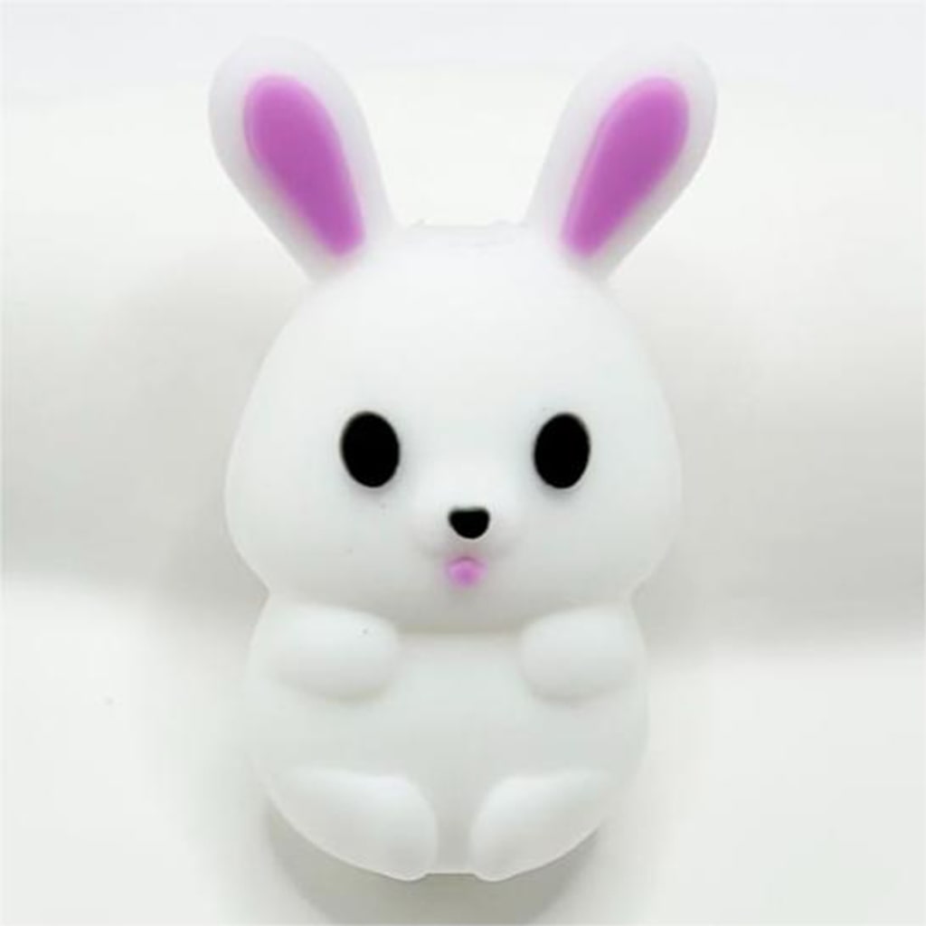 A silicone bead in the shape of a white 3D little rabbit bunny with pink inner ears.

