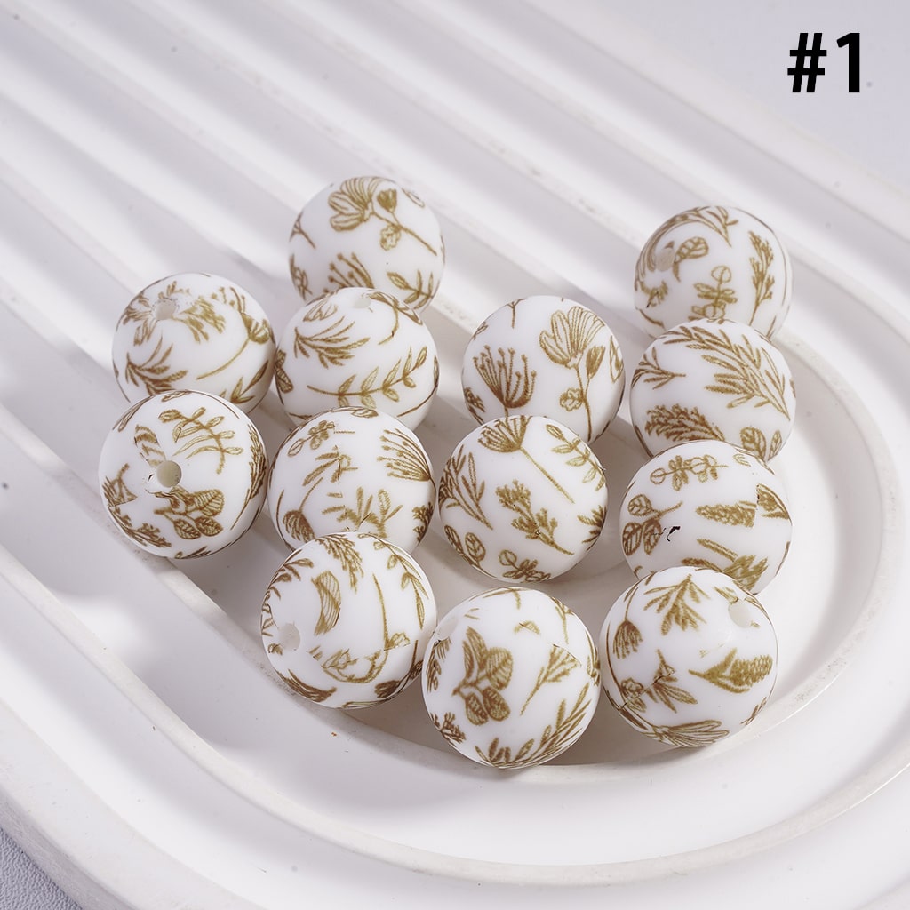White spherical candies with gold floral patterns on a white plate

