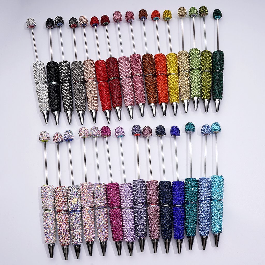 Colorful bling pens arranged in rows on a white background

