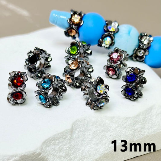 A collection of gun black metal alloy flower spacers with colorful rhinestones inside, displayed alongside a measurement indication of '13mm'.

