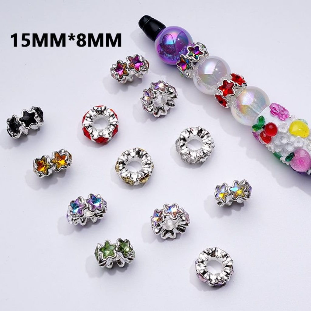 A collection of silver alloy star-shaped spacer beads with colorful shiny rhinestones in assorted colors.

