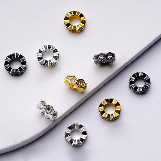 Set of round metallic earrings in gold, silver, and black on a white surface.


