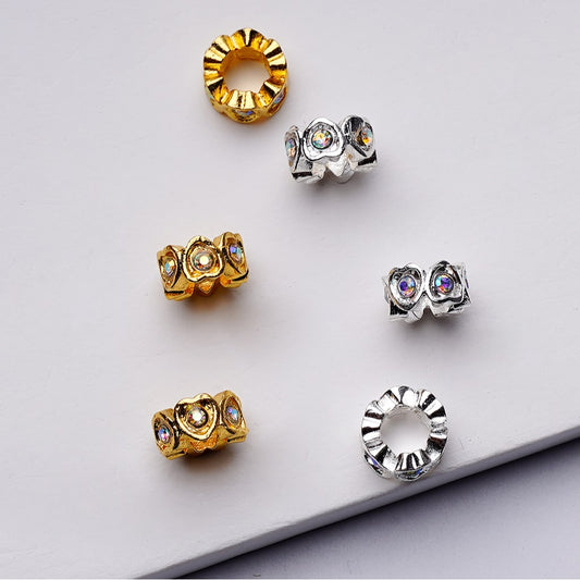 Gold and silver jewelry pieces with gemstones on a light gray background

