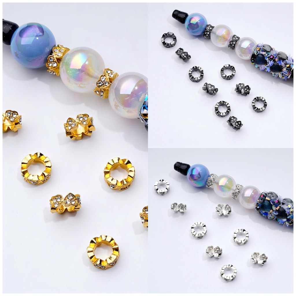 A collection of heart-shaped spacer beads in gold, silver, and gun black metal with clear rhinestones.


