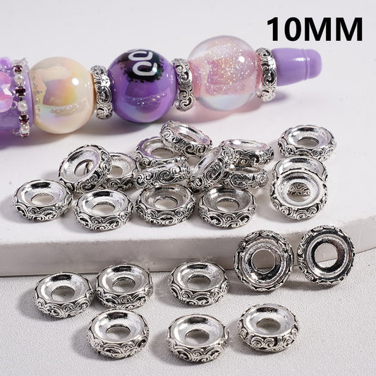 Silver beads with a bracelet featuring purple and pink beads on a white background.

