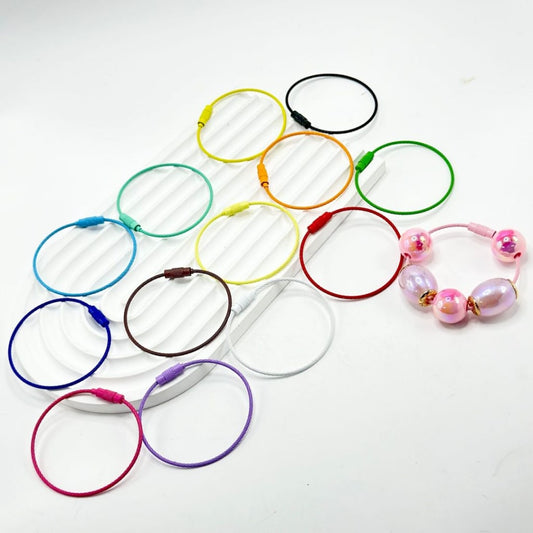 A collection of colorful beadable metal keychain ring loops, some with beads attached, displayed on a white background.

