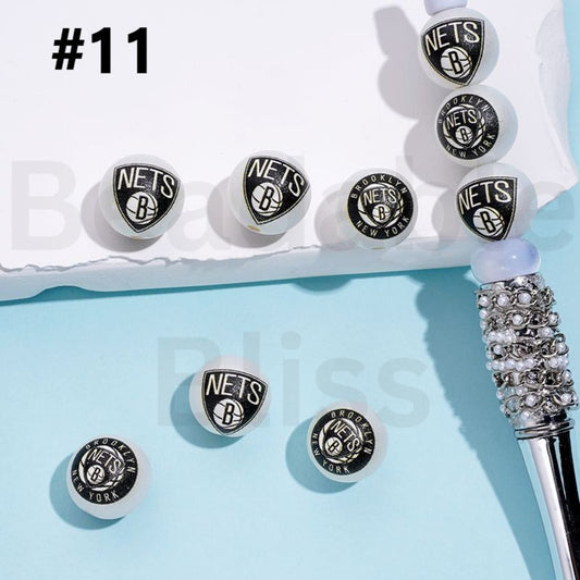 Silver earrings with 'NETS' logo on a light blue background

