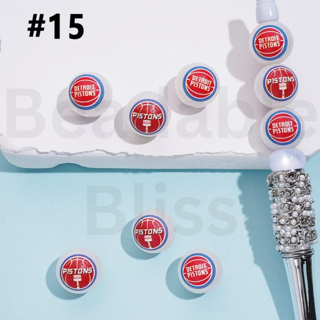 Detroit Pistons-themed earrings on a light blue background with 'beadablebliss.com' branding.

