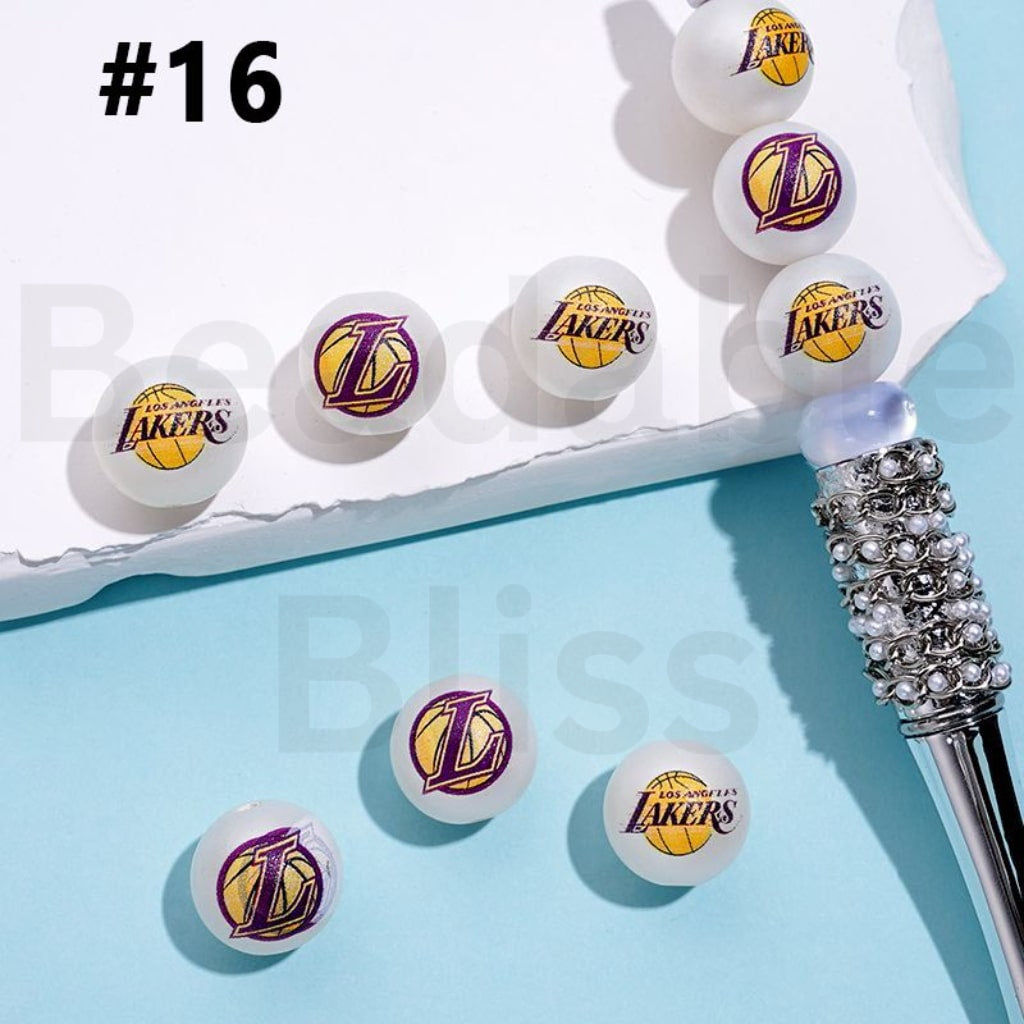 Lakers branded ping pong balls on a blue surface with a close-up of one ball.

