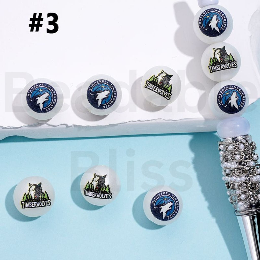 Set of white earrings with Timberwolves logo on a light blue background

