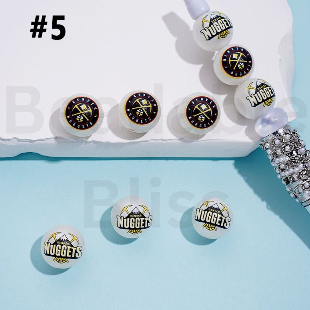 Basketball-themed earrings with 'Nuggets' logo on a light blue background


