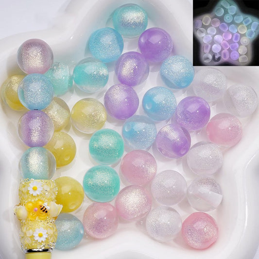 Pastel-colored glittery beads on a white plate with a close-up inset showing their luster.

