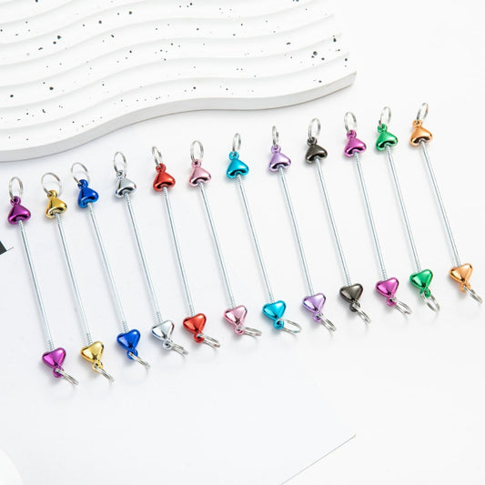 A collection of metallic color keychain bars with heart designs, displayed in a row on a light background.

