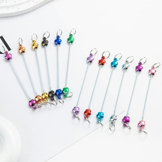 A collection of metallic color beadable keychain bars with flower designs, displayed in a fanned arrangement on a white surface.

