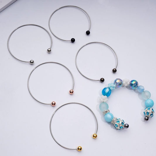Set of silver necklaces with beads on a light gray background


