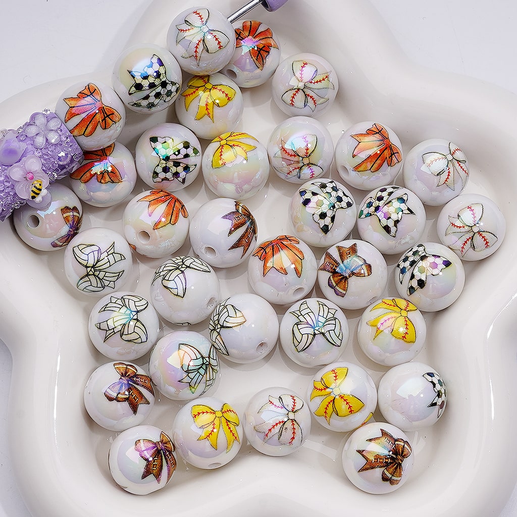 White beads with colorful butterfly designs on a white plate

