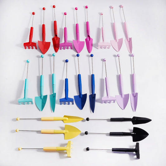 Set of colorful gardening tools including shovels, rakes, and hoes on a white background

