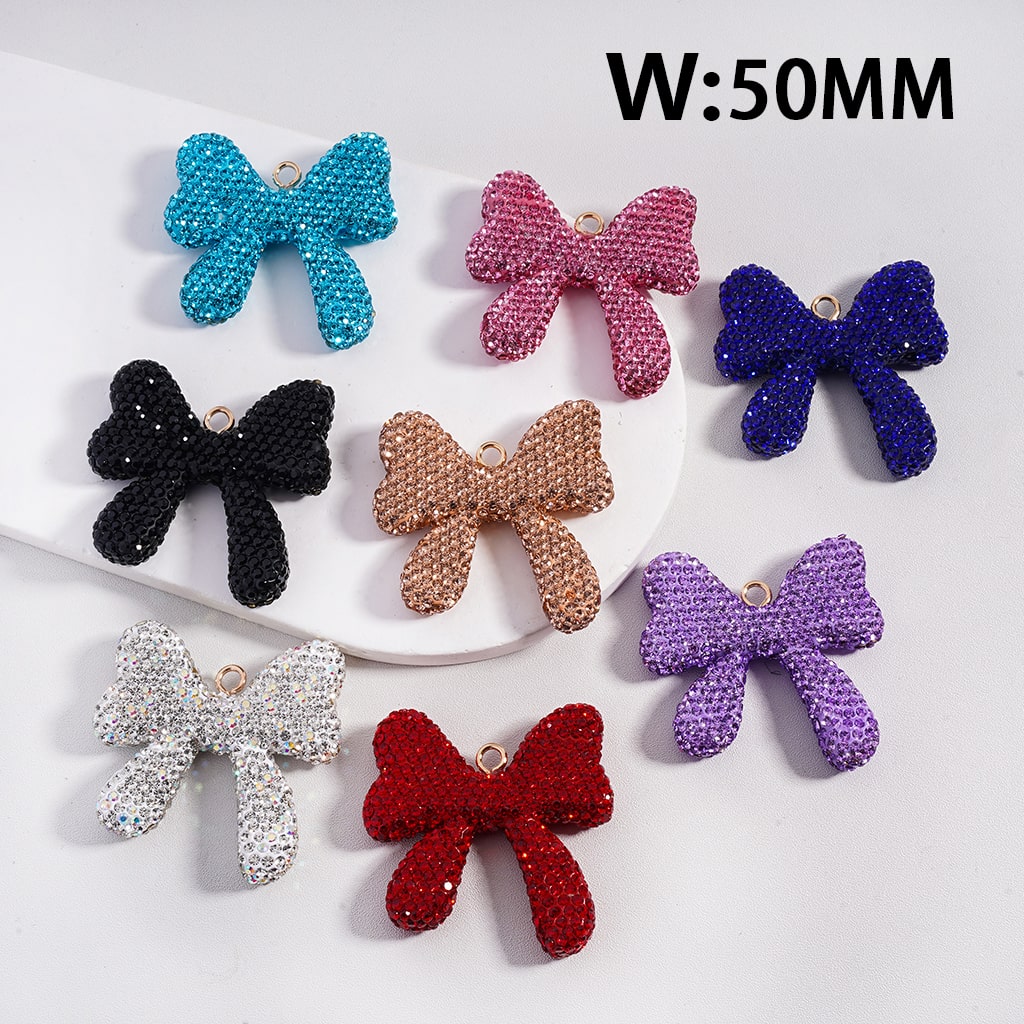 Colorful glittery bow-shaped charms on a white background with 'W:50MM' text.

