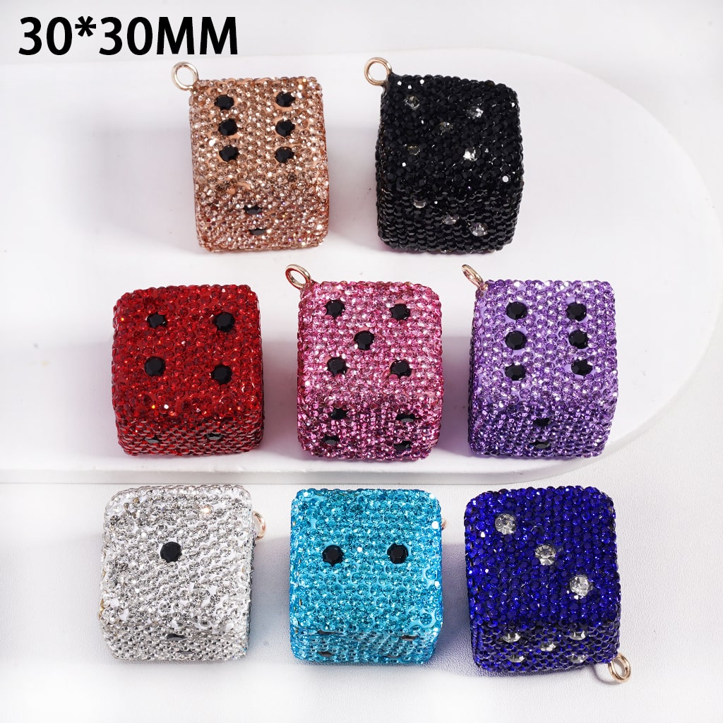 Set of glittery dice-shaped containers in various colors on a white background

