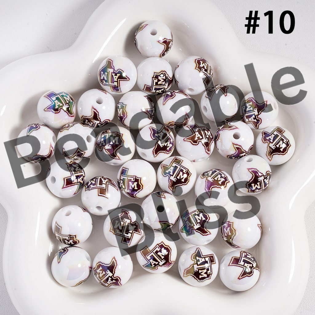 White beads with colorful designs arranged on a white surface

