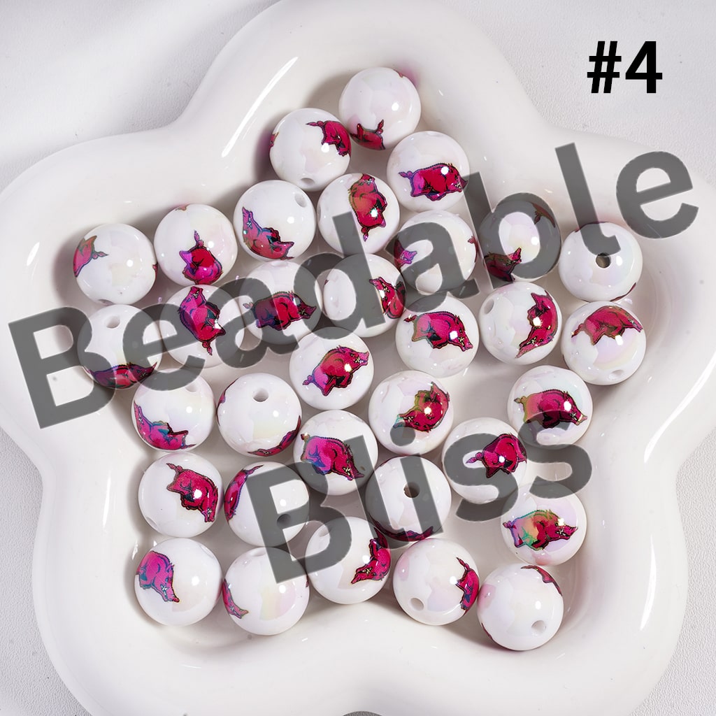 White beads with pink and red floral designs on a white plate, branded 'Beadable Bliss'.

