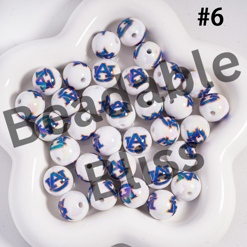 White beads with blue and gold designs on a white plate, labeled 'Beadable Bliss'.


