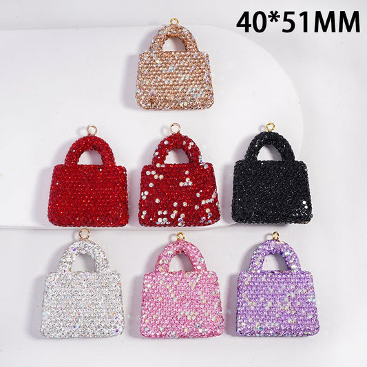 Set of six small handbag-shaped pendants in various colors on a white background.