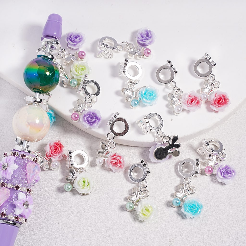 Colorful charm bracelets with floral and heart designs on a white background