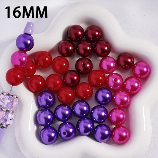 Assorted red, purple, and pink beads on a white heart-shaped dish with '16MM' text.