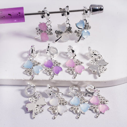 Butterfly-shaped charms with pastel colors on a white background