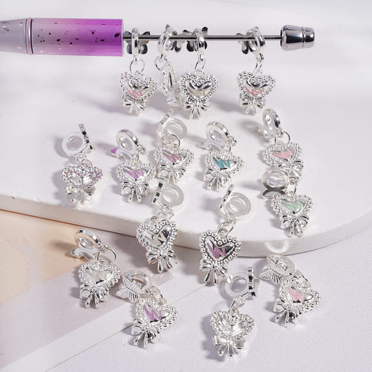 Silver heart-shaped charms with crystals on a white background